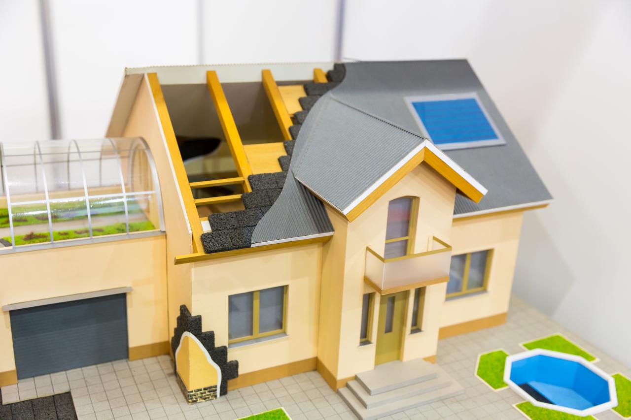 Model of house, thermal insulation of roof concept. Energy and money saving materials and systems